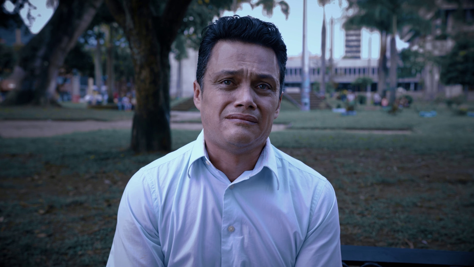 Los protagonistas de El Oportunista conversando bajo las sombras de noche
