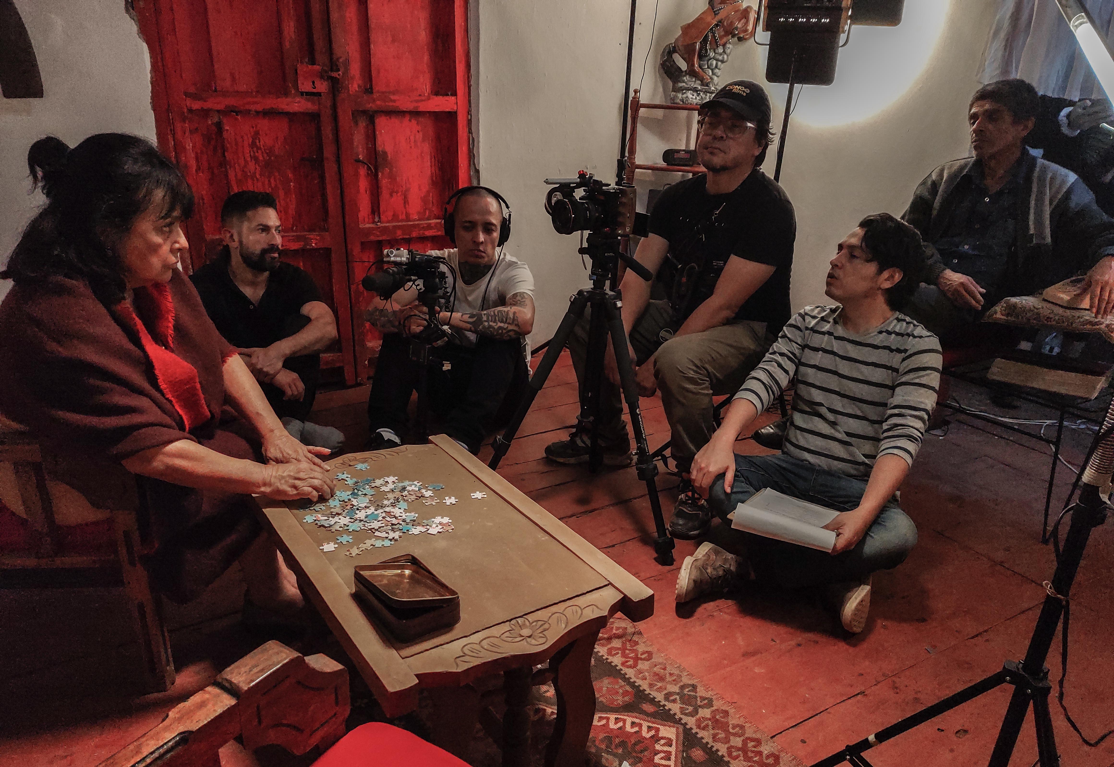 Behind the scenes shot revealing the camera setup and crew working in a low-light environment, highlighting the production's technical precision.